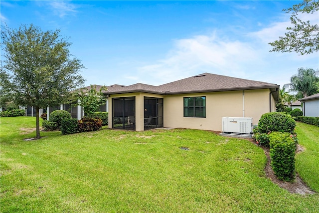 rear view of property featuring a yard and a sunroom