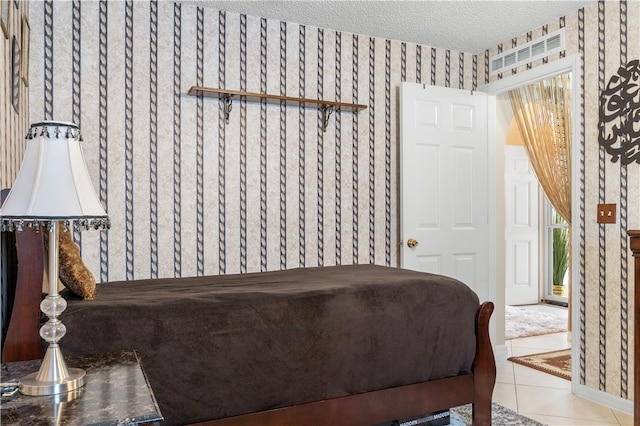 bedroom with a textured ceiling and light tile patterned flooring