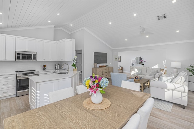 dining space featuring ceiling fan, sink, vaulted ceiling, wood ceiling, and light wood-type flooring