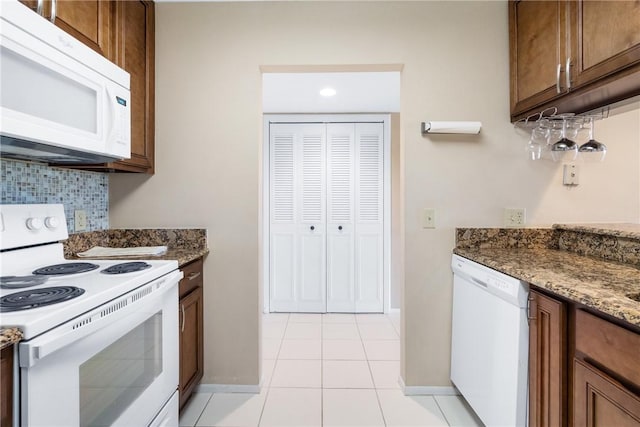 41 Plantation Dr Unit 202, Vero Beach, FL 32966 - kitchen featuring white appliances, tasteful backsplash, light tile patterned flooring, and baseboards
