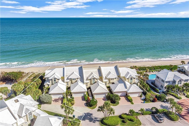 birds eye view of property with a water view and a beach view