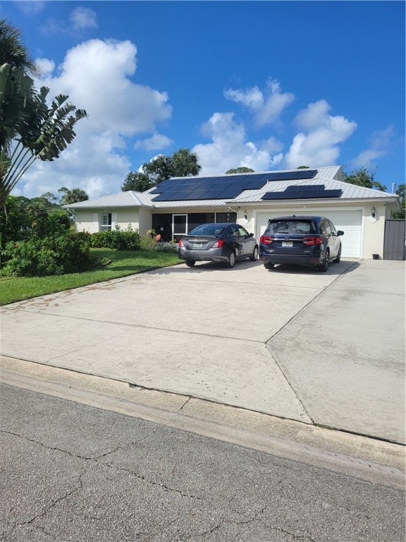 view of front of house featuring solar panels and a garage