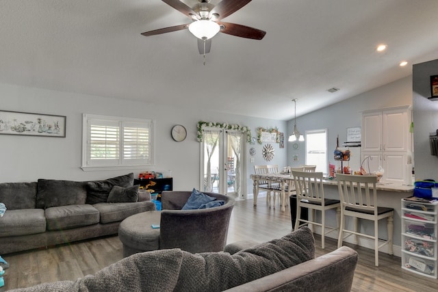 living room with ceiling fan, lofted ceiling, and light wood-type flooring