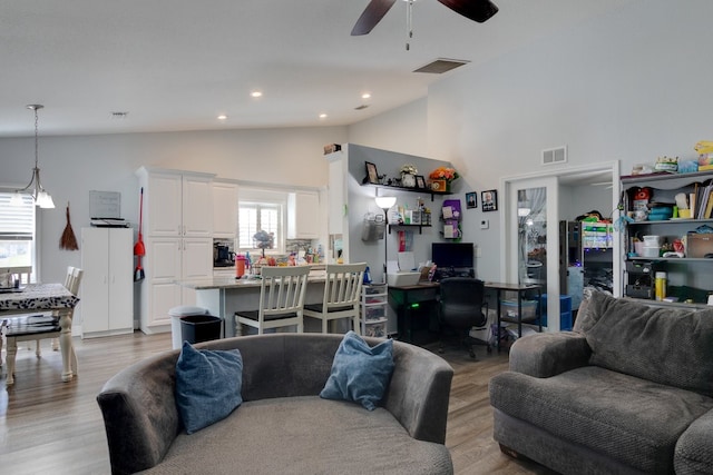 living room featuring high vaulted ceiling, ceiling fan, light hardwood / wood-style floors, and a wealth of natural light