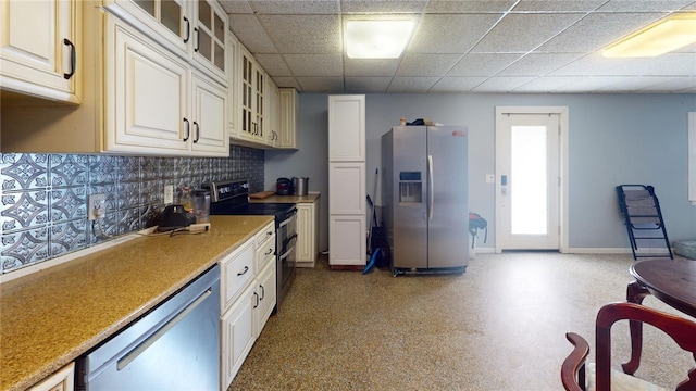 kitchen featuring stainless steel appliances, a drop ceiling, and decorative backsplash