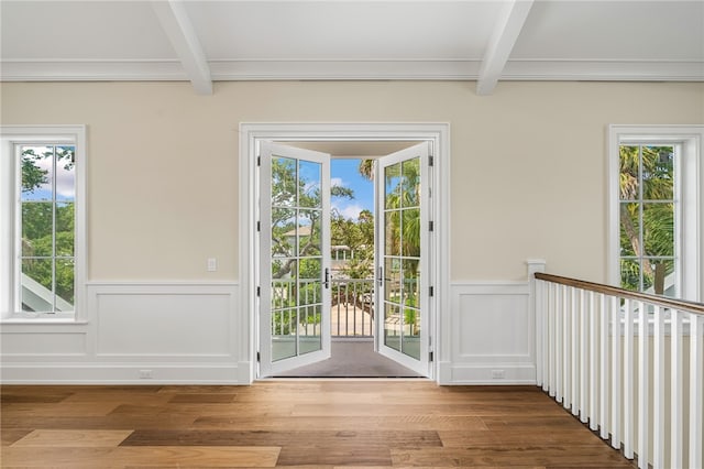 doorway featuring beamed ceiling and hardwood / wood-style flooring