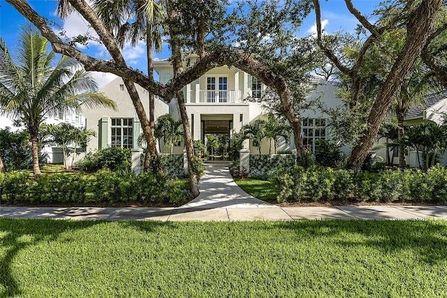 view of front of property featuring a front yard and a balcony