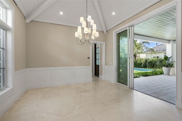 interior space with wooden ceiling, a chandelier, plenty of natural light, and lofted ceiling with beams