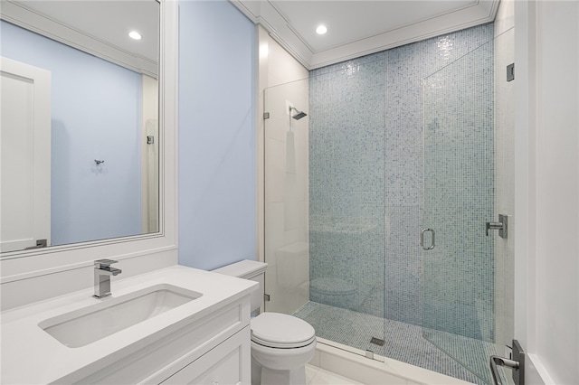 bathroom with a shower with door, vanity, toilet, and ornamental molding