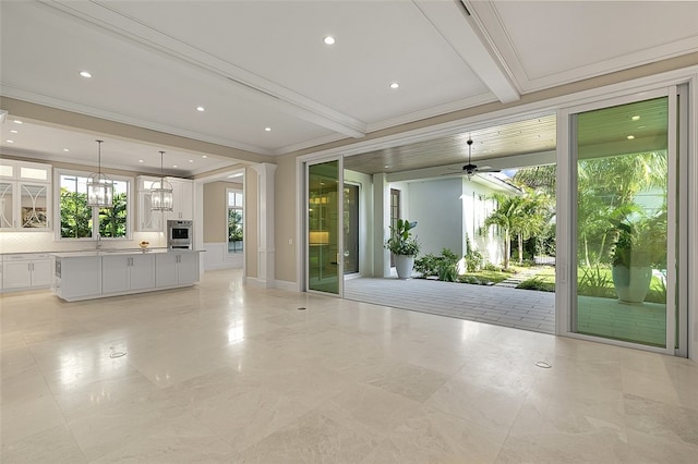 entryway with sink, ceiling fan with notable chandelier, and beam ceiling