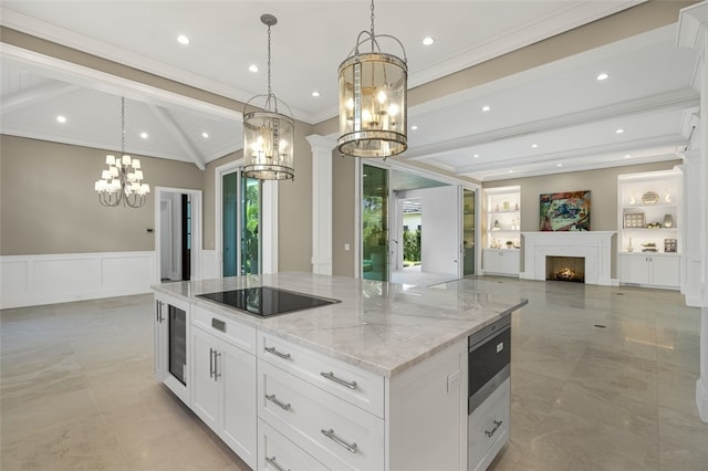 kitchen featuring a spacious island, hanging light fixtures, white cabinets, and black electric stovetop