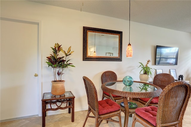 dining area featuring a textured ceiling and light tile patterned floors