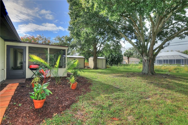 view of yard featuring a sunroom and a storage unit