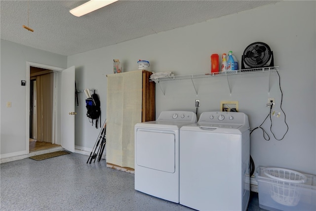 laundry area featuring washing machine and dryer and a textured ceiling