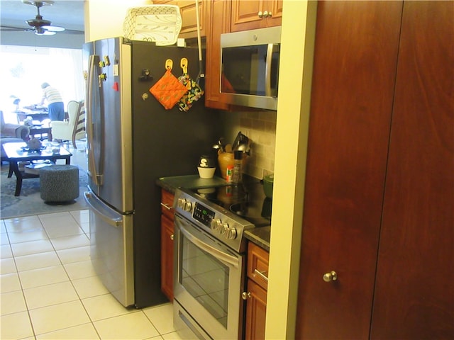 kitchen with light tile patterned floors, stainless steel appliances, tasteful backsplash, and ceiling fan