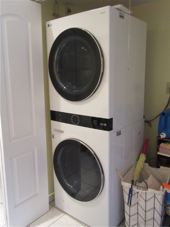 laundry area featuring light tile patterned flooring and stacked washer and dryer