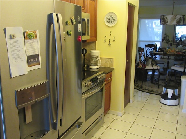 kitchen featuring appliances with stainless steel finishes, tasteful backsplash, and light tile patterned floors