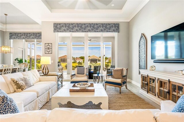 9266 Orchid Cove Cir, Vero Beach, FL 32963 - living room featuring ceiling fan, wood finished floors, a raised ceiling, and crown molding