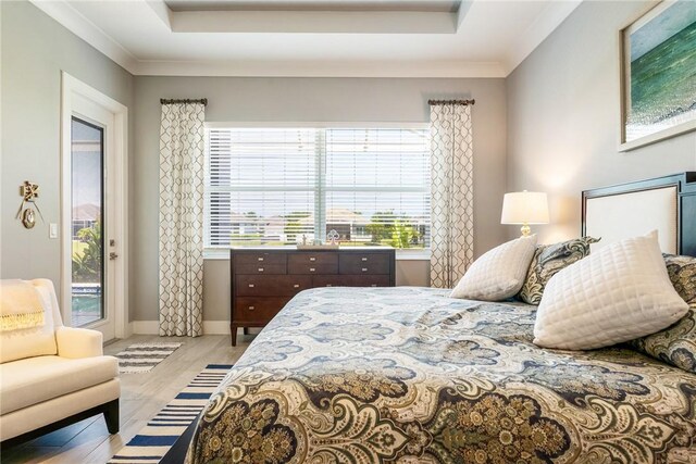9266 Orchid Cove Cir, Vero Beach, FL 32963 - bedroom featuring access to outside, a raised ceiling, light wood finished floors, and crown molding