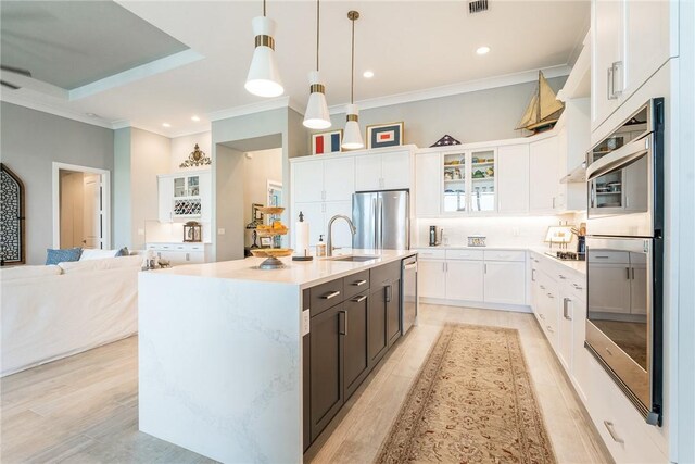 9266 Orchid Cove Cir, Vero Beach, FL 32963 - kitchen with stainless steel appliances, glass insert cabinets, white cabinets, light countertops, and decorative light fixtures