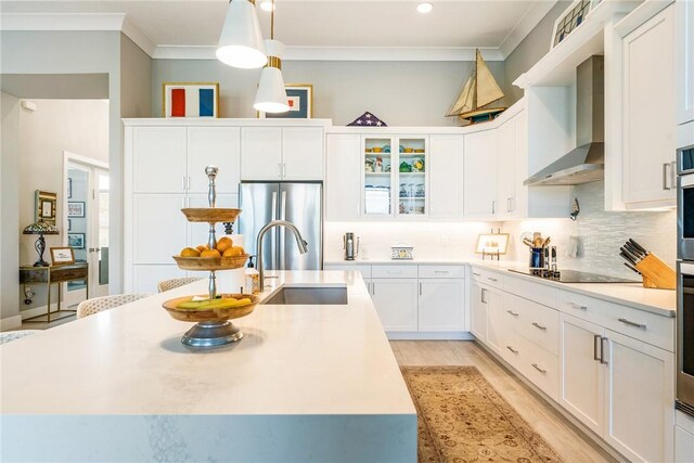 9266 Orchid Cove Cir, Vero Beach, FL 32963 - kitchen featuring wall chimney exhaust hood, freestanding refrigerator, ornamental molding, black electric cooktop, and backsplash
