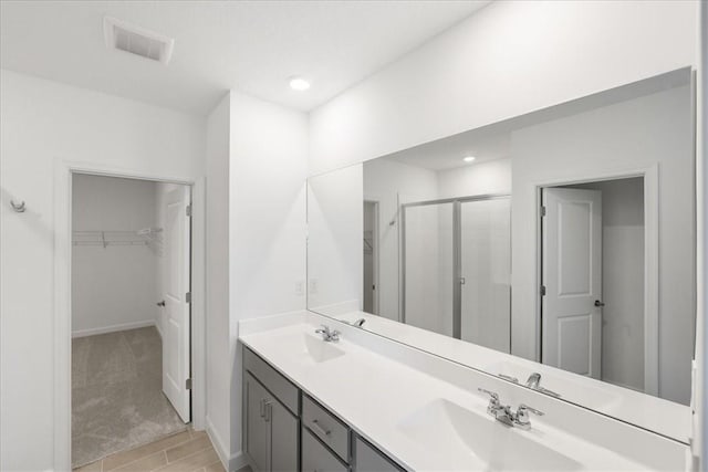 3544 Angler Dr, Fort Pierce, FL 34946 - full bath featuring a stall shower, a walk in closet, double vanity, and wood finished floors