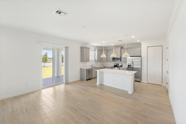 3544 Angler Dr, Fort Pierce, FL 34946 - kitchen with appliances with stainless steel finishes, gray cabinetry, light countertops, a kitchen island, and light wood-style floors