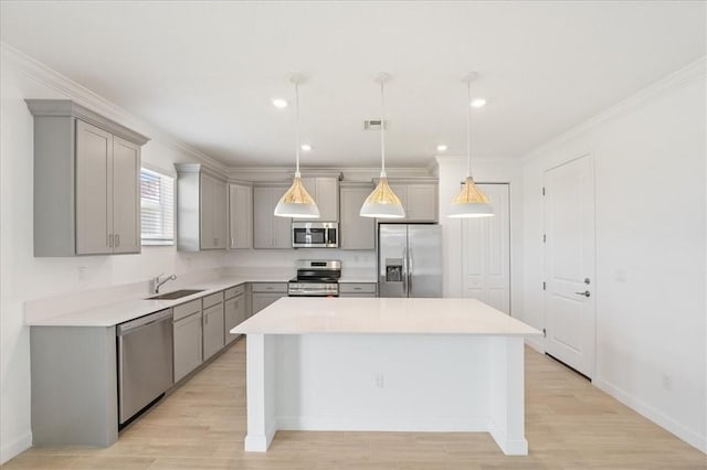 3544 Angler Dr, Fort Pierce, FL 34946 - kitchen with stainless steel appliances, gray cabinetry, a kitchen island, light countertops, and crown molding