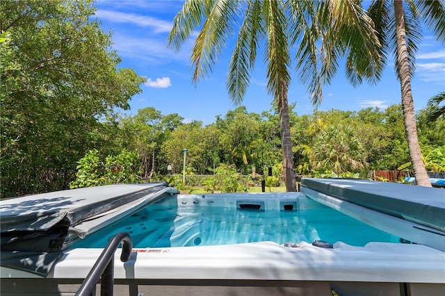 view of swimming pool featuring a hot tub