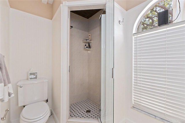 bathroom featuring toilet and a tile shower