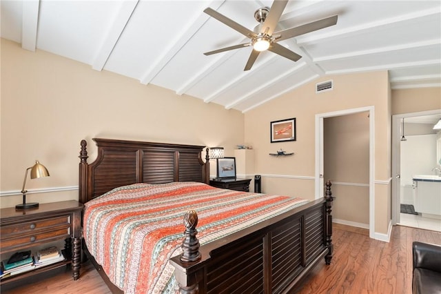 bedroom featuring ceiling fan, hardwood / wood-style flooring, and vaulted ceiling with beams