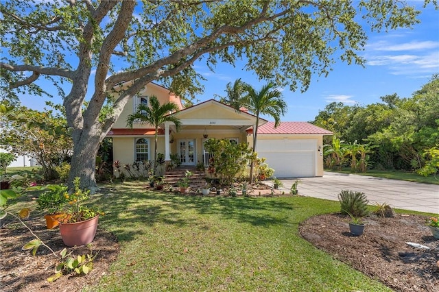 view of front of property featuring a front lawn, a garage, and french doors