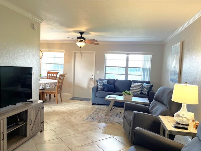 living room featuring a wealth of natural light, a ceiling fan, crown molding, and light tile patterned flooring