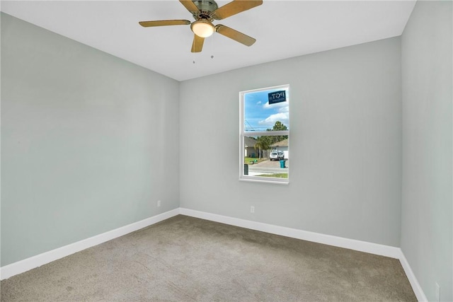 carpeted spare room with ceiling fan