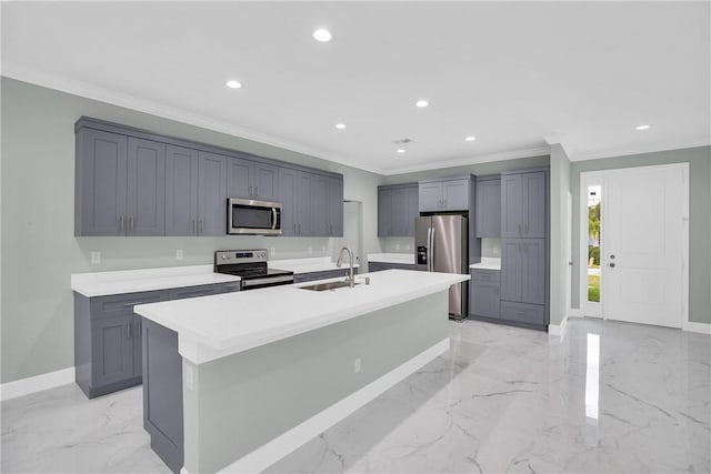 kitchen with stainless steel appliances, a kitchen island with sink, crown molding, sink, and gray cabinets