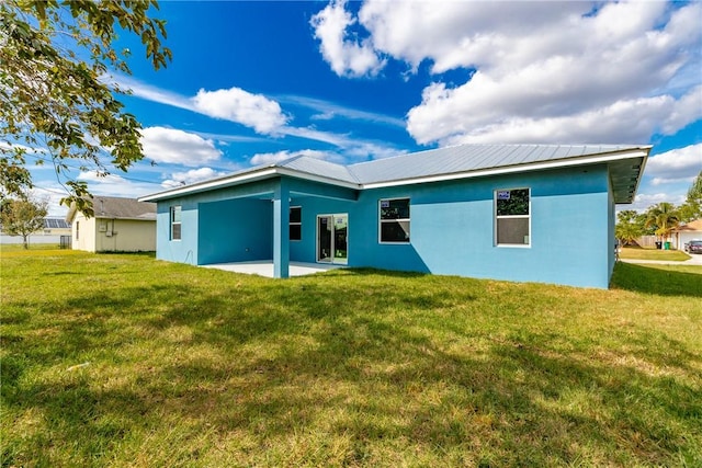 back of property with a patio area and a yard