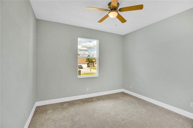 carpeted spare room featuring ceiling fan