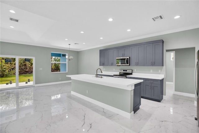 kitchen with appliances with stainless steel finishes, gray cabinetry, a kitchen island with sink, decorative light fixtures, and an inviting chandelier