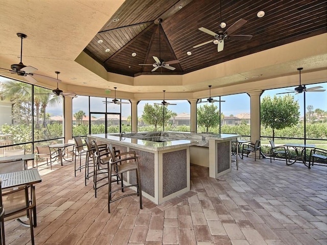 view of patio featuring ceiling fan and a bar