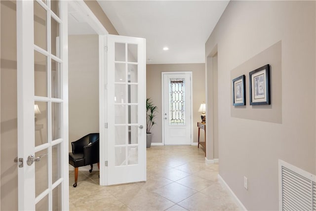 hall featuring light tile patterned floors and french doors