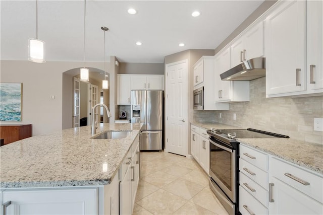 kitchen featuring sink, white cabinetry, decorative light fixtures, stainless steel appliances, and a kitchen island with sink