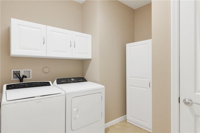 laundry area with cabinets, light tile patterned flooring, and separate washer and dryer