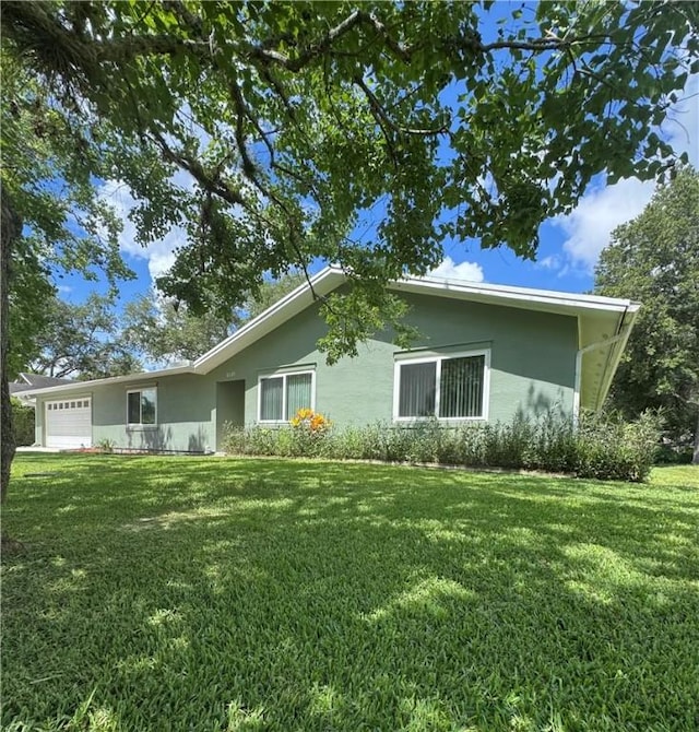 2525 84th Ter, Vero Beach, FL 32966 - view of home's exterior with stucco siding, an attached garage, and a lawn