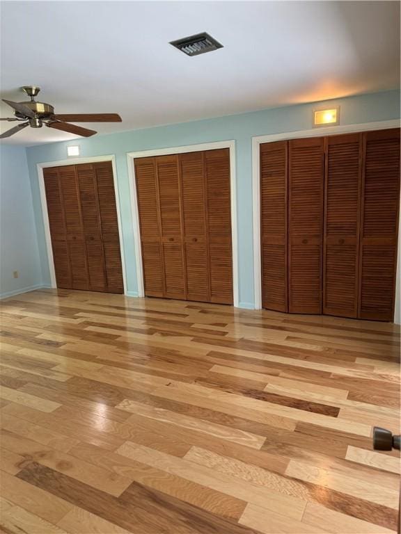 2525 84th Ter, Vero Beach, FL 32966 - unfurnished bedroom with light wood-type flooring, multiple closets, and ceiling fan