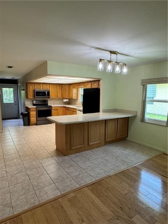 2525 84th Ter, Vero Beach, FL 32966 - kitchen featuring stainless steel appliances, a peninsula, light countertops, and plenty of natural light