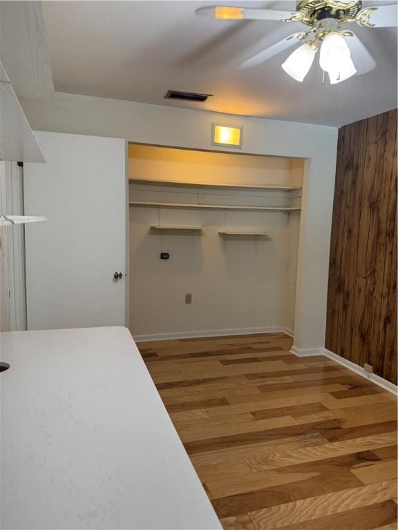 2525 84th Ter, Vero Beach, FL 32966 - bedroom featuring light wood-style flooring, wooden walls, a closet, and ceiling fan