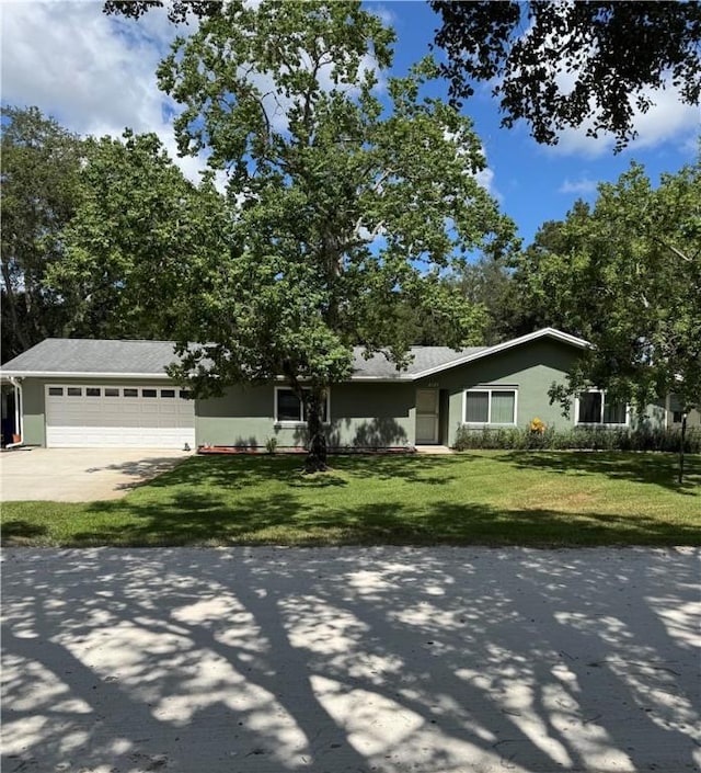 2525 84th Ter, Vero Beach, FL 32966 - view of front of home with an attached garage, concrete driveway, a front lawn, and stucco siding