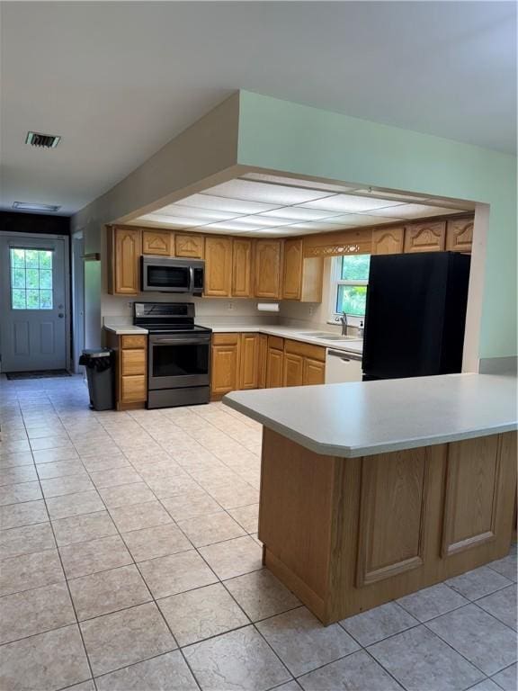 2525 84th Ter, Vero Beach, FL 32966 - kitchen featuring appliances with stainless steel finishes, light countertops, healthy amount of natural light, and light tile patterned floors