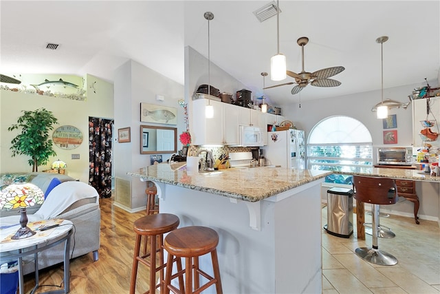 kitchen with white appliances, hanging light fixtures, ceiling fan, light wood-type flooring, and white cabinetry