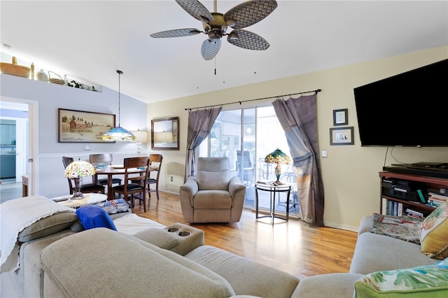 living room featuring ceiling fan, light wood-type flooring, and vaulted ceiling